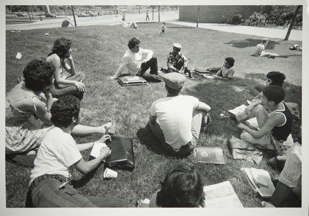 Students sitting in a circle on the lawn outside of the Behavioral Sciences building