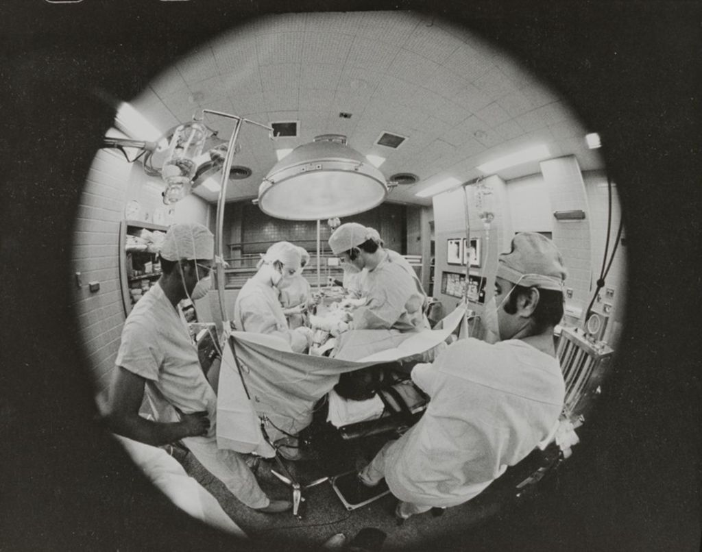 Miniature of Fish-eye view of students watching over a patient during surgery