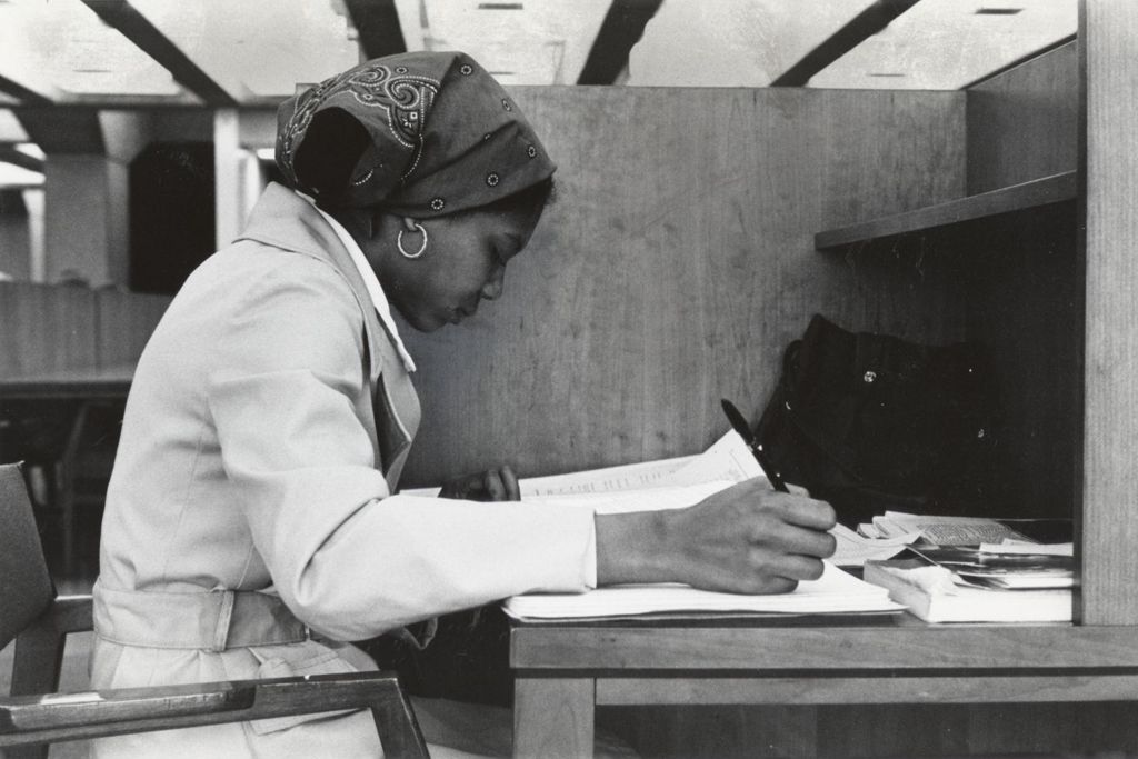 Student sitting at a desk in the Richard J. Daley Library