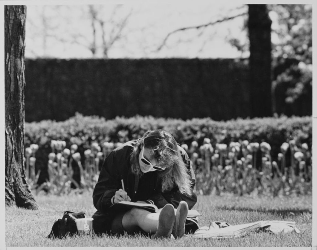 Student sitting in the grass on campus