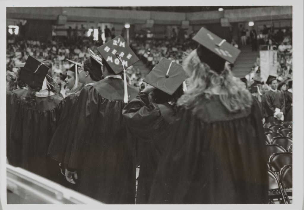 Students with decorated mortarboards in line at the graduation ceremony