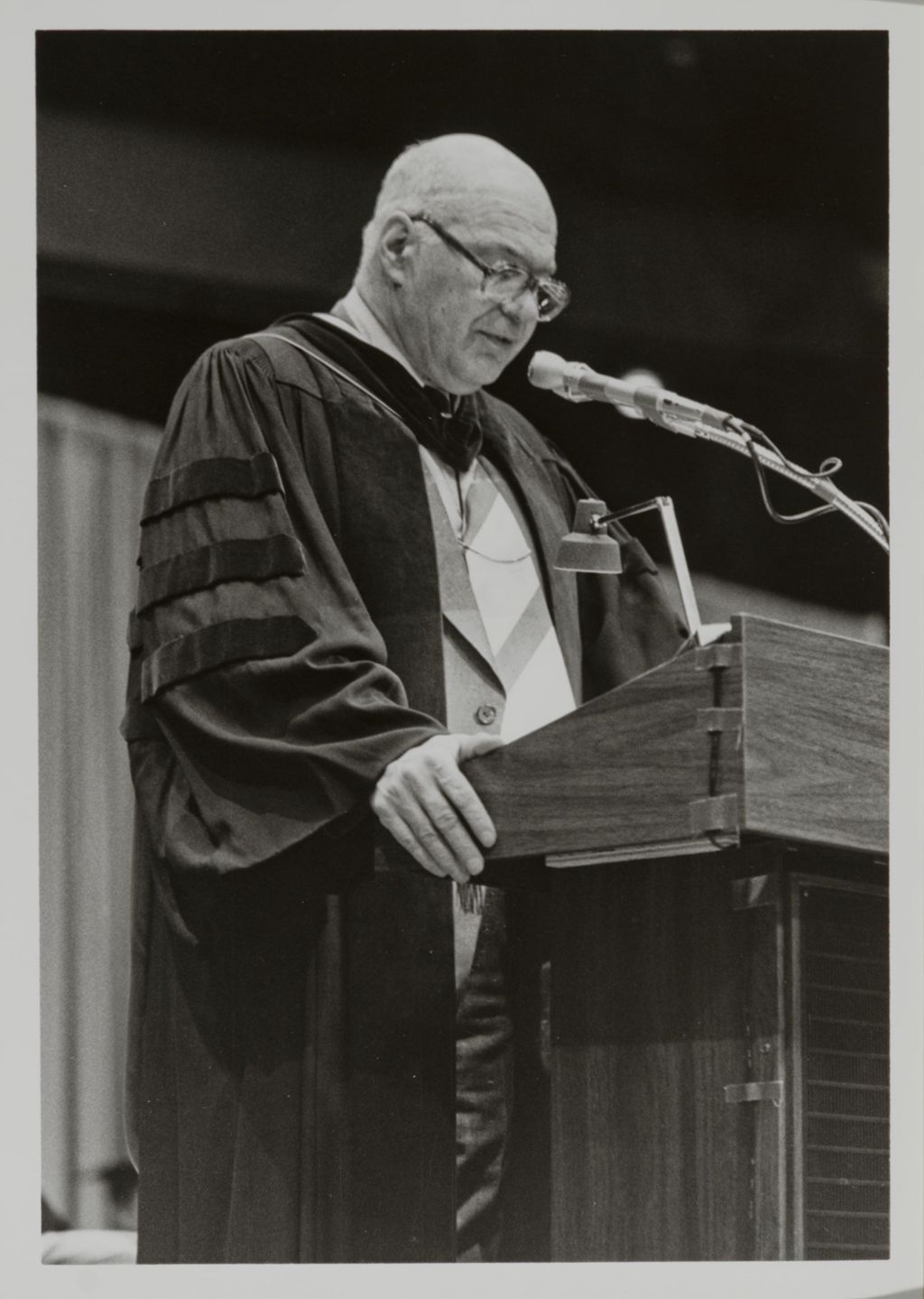 Miniature of Chancellor Donald H. Riddle addressing the audience at the graduation ceremony