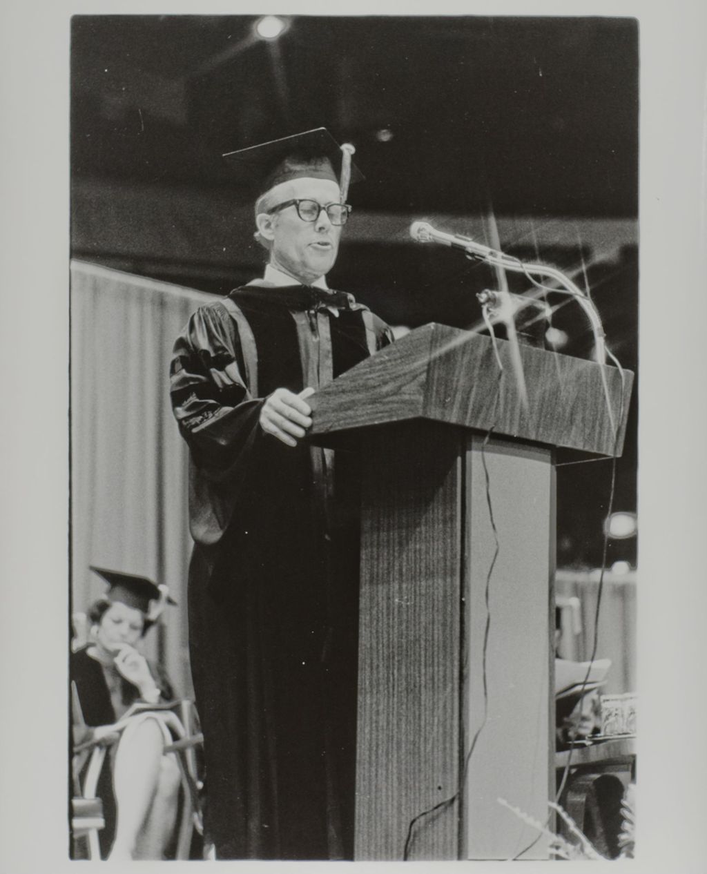 Miniature of Person addressing the crowd from the podium at the graduation ceremony