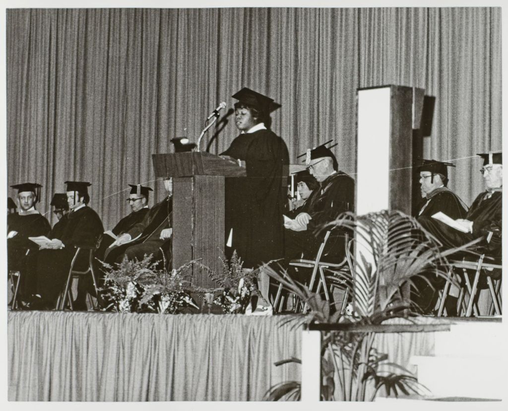 Person addressing the crowd at the graduation ceremony