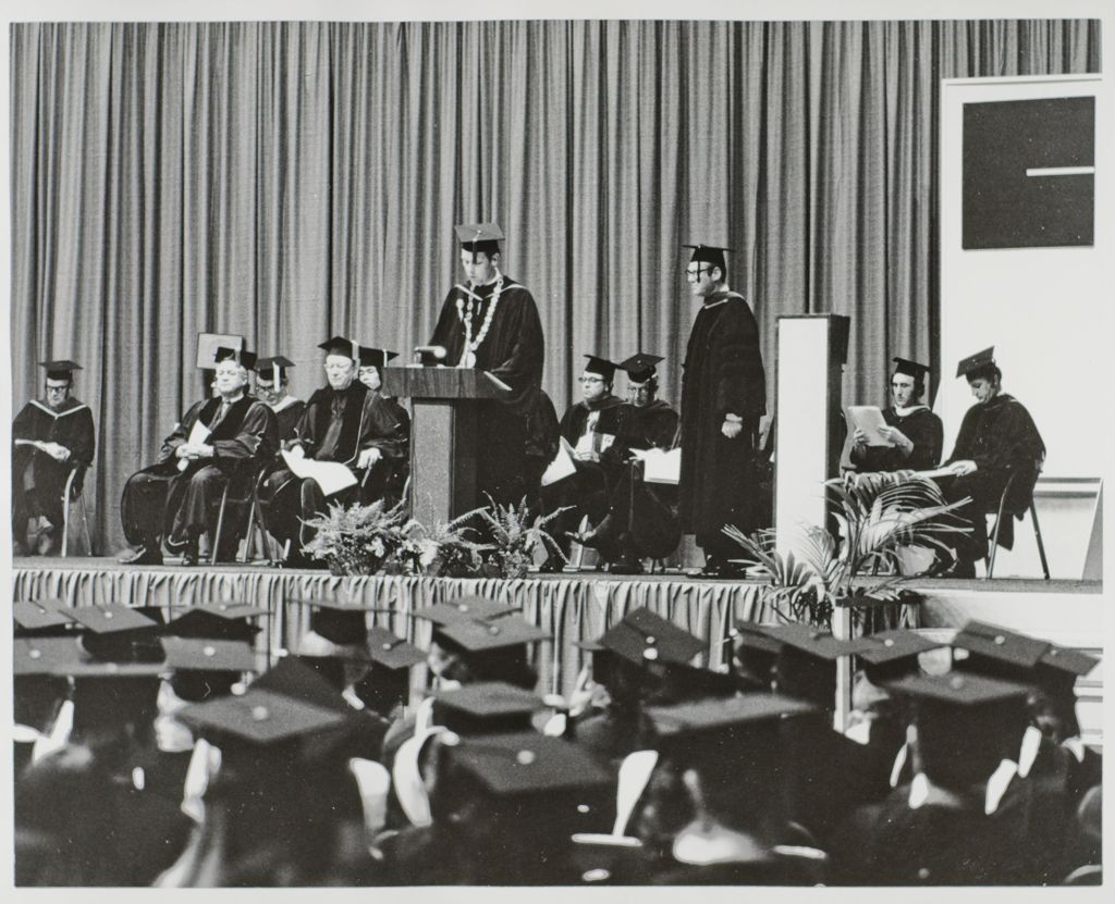 Miniature of University of Illinois President, John E. Corbally, at the podium at the graduation ceremony