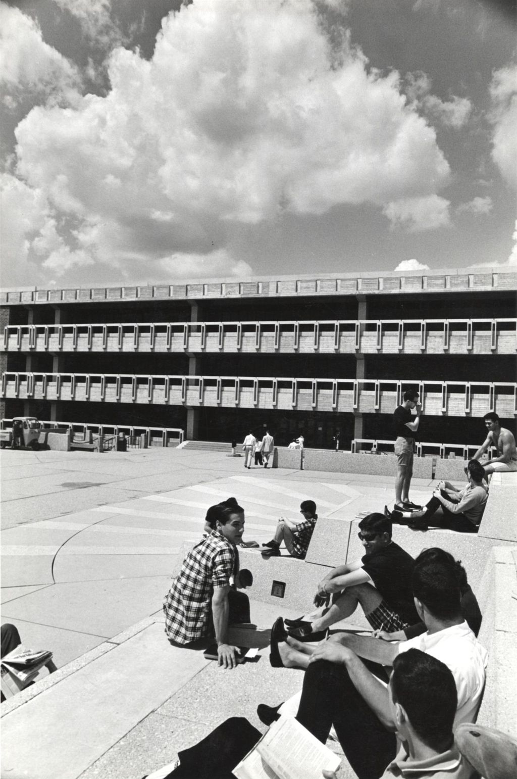 Students sitting on the Great Court. Richard J. Daley Library in the background