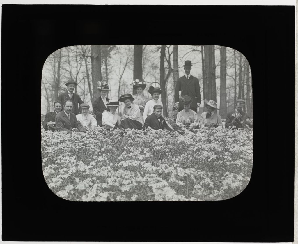 Men and Women Sitting in Field of Flowers