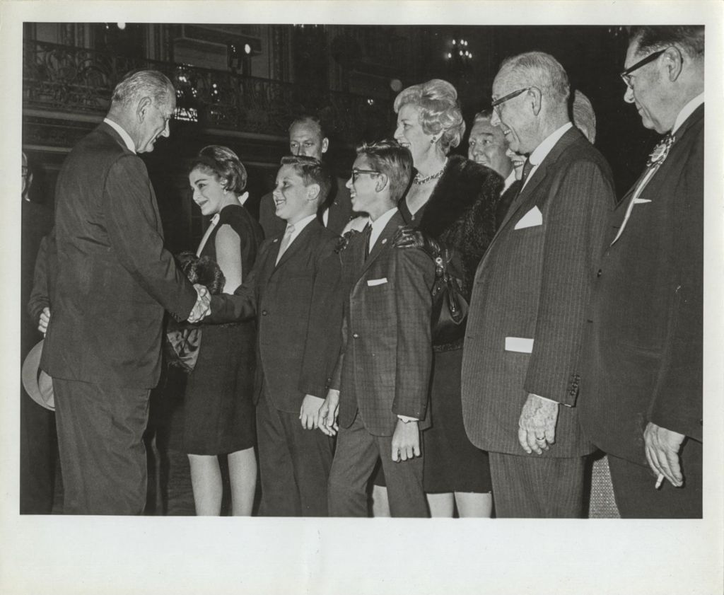 Lyndon B. Johnson shaking hands with a boy
