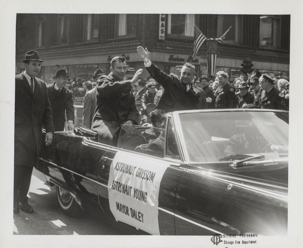 Astronauts John Young and Gus Grissom wave to the crowd during a parade in their honor