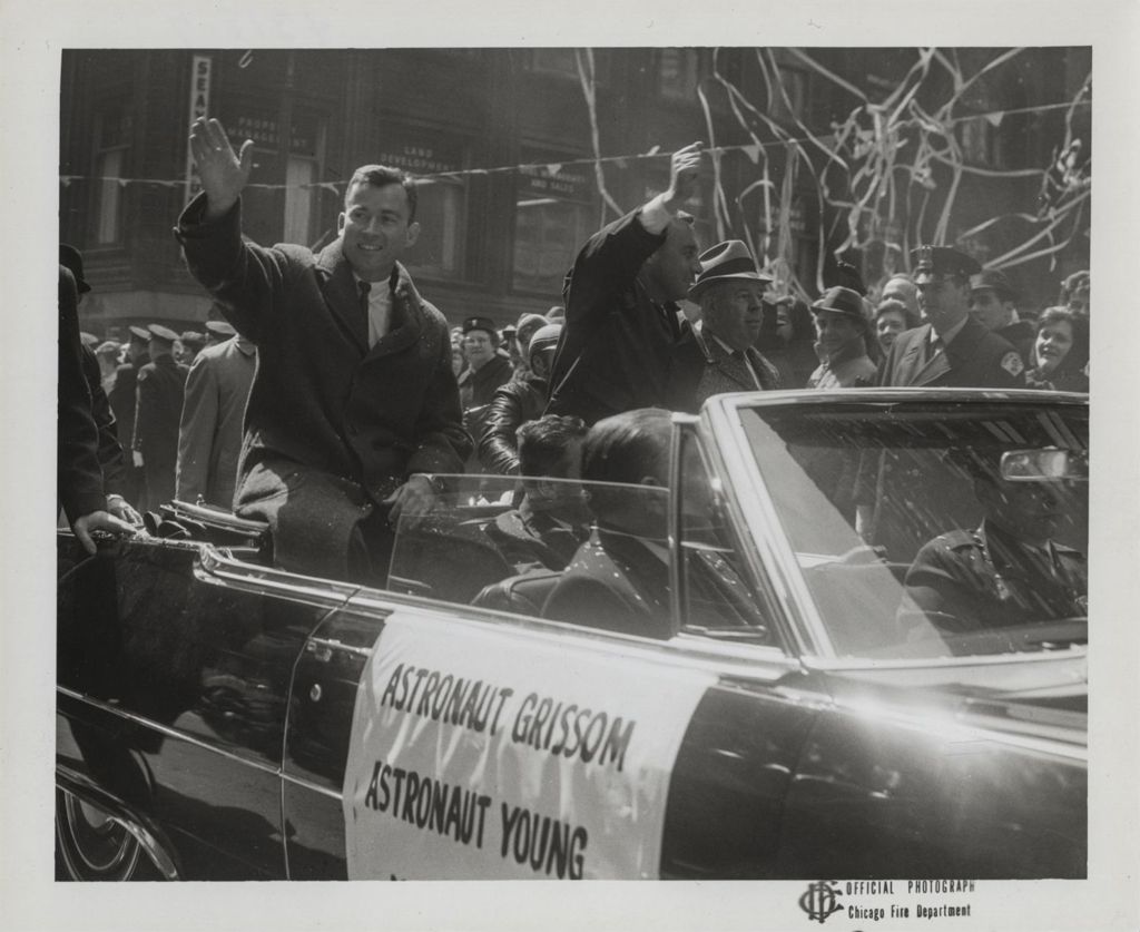 Astronauts John Young and Gus Grissom wave to the crowd during a parade in their honor