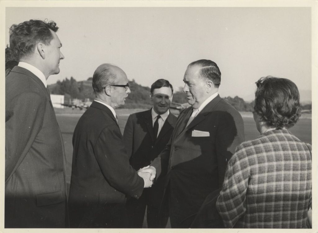 Richard J. Daley shaking hands with man at airport in Rome