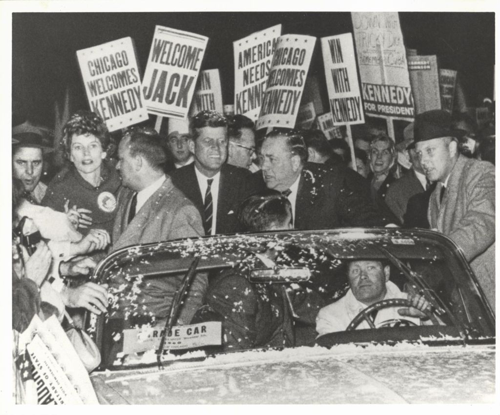 John F. Kennedy and Richard J. Daley riding in a torchlight parade