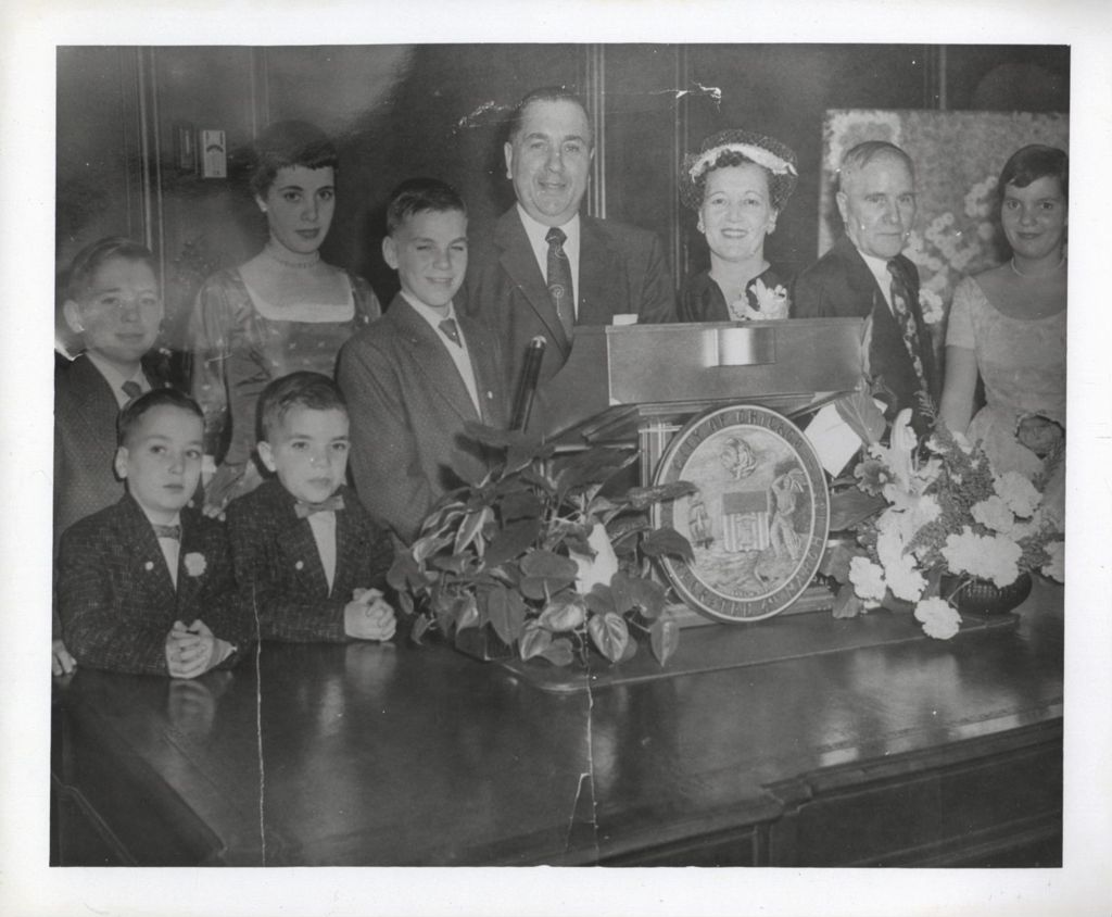 Miniature of The Daley family gathered around a podium during Richard J. Daley's first mayoral inauguration