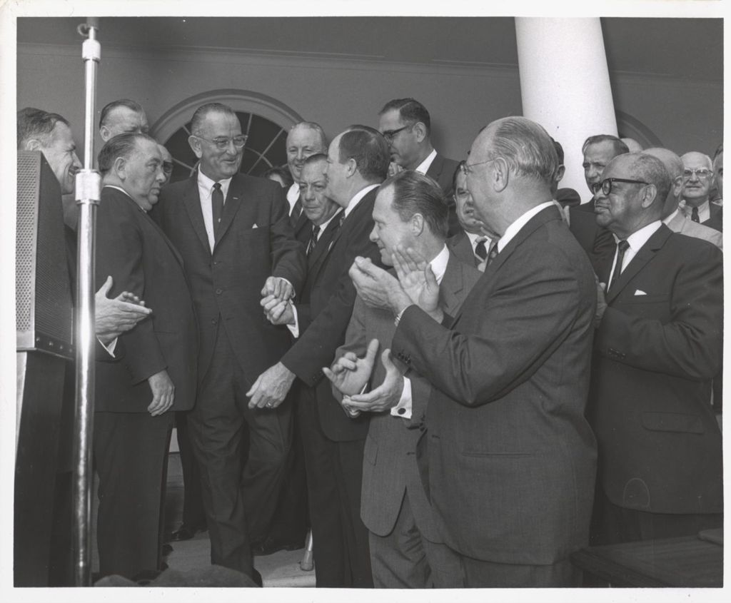 Miniature of Lyndon B. Johnson receives applause at the White House
