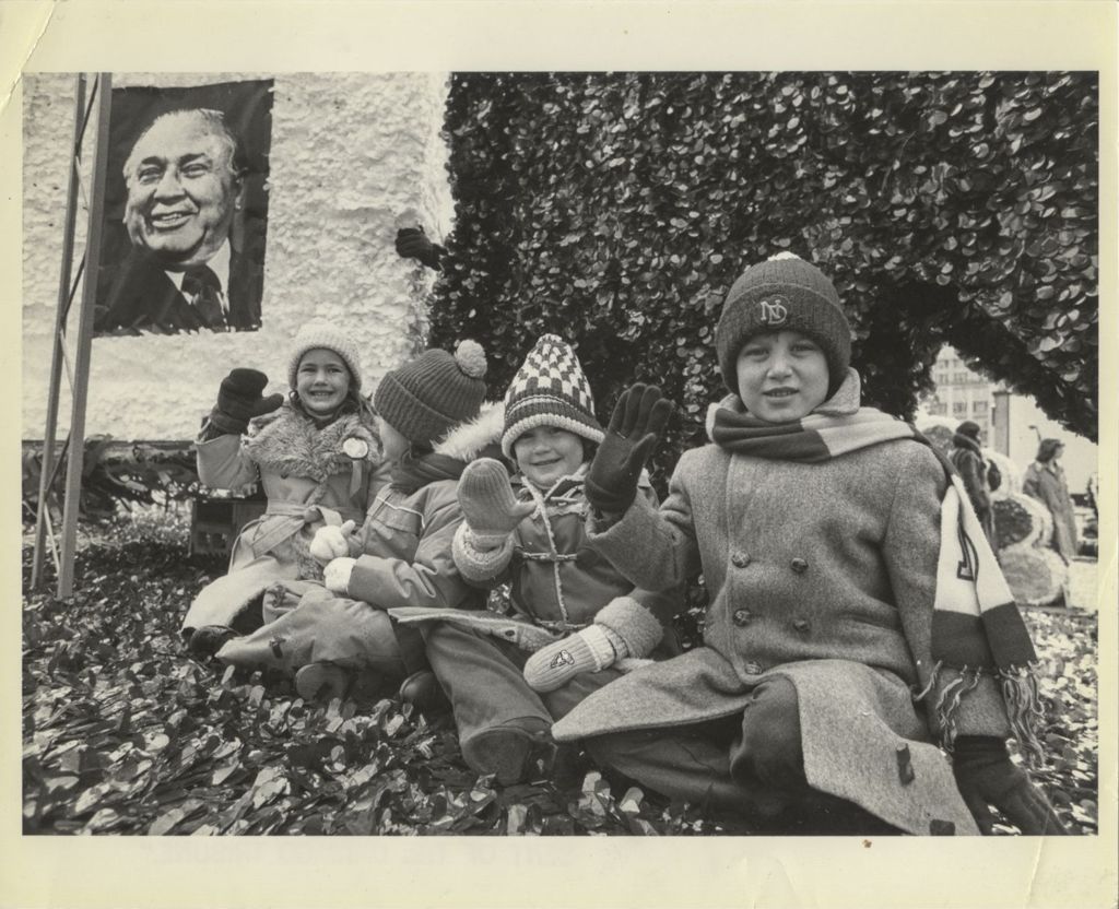 Group of four children waving on a parade float