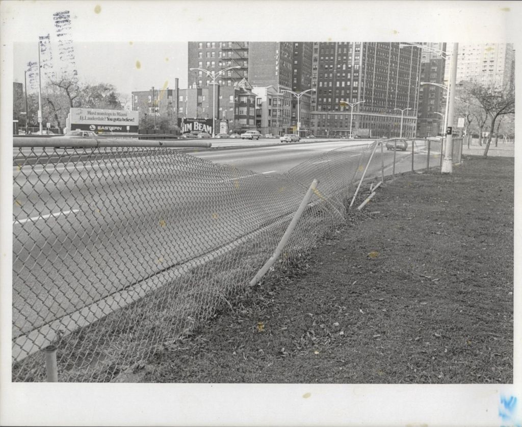 Highway view with damaged chain-link fence