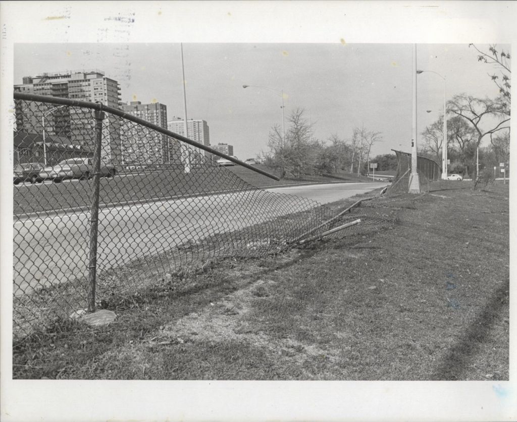Highway view with damaged chain-link fence