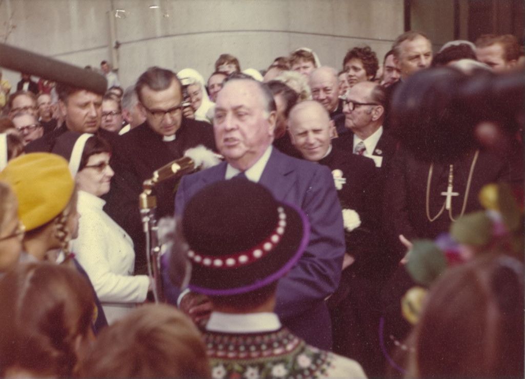 Richard J. Daley at a microphone with clergy behind him