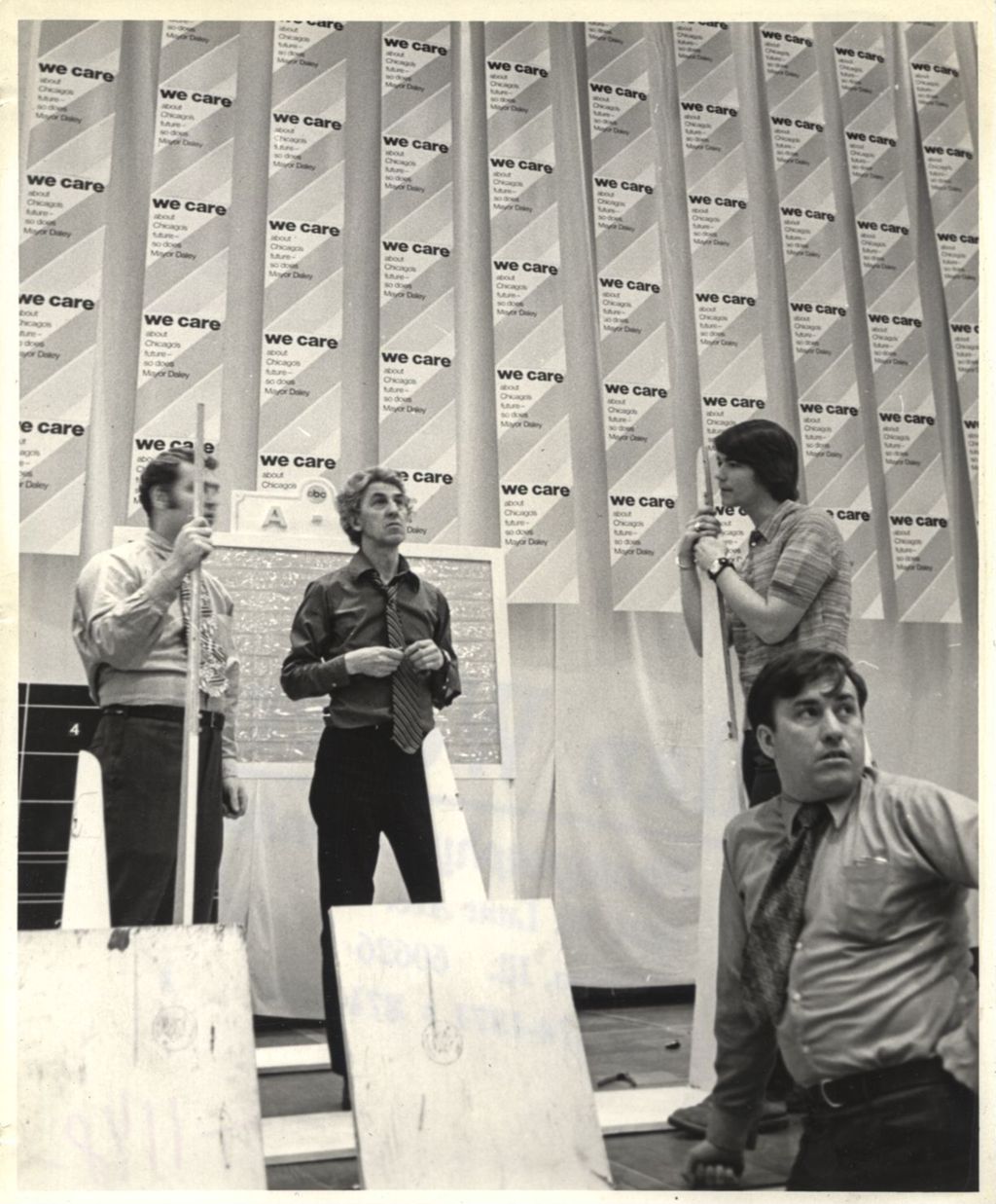 Four men setting up a room for a "We Care" election event