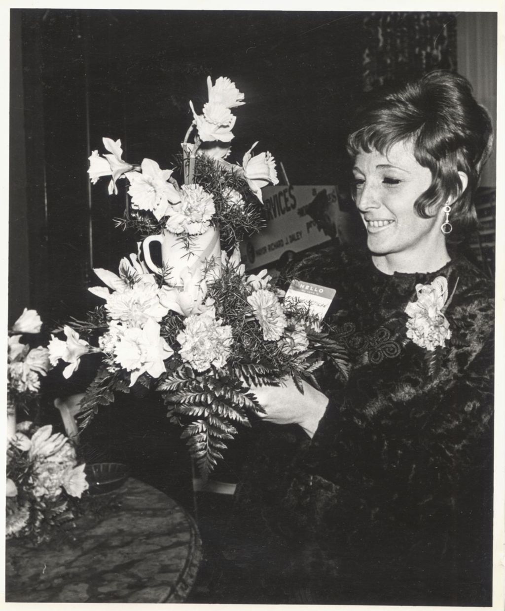 Marge Hartigan holding bouquet of flowers at a "We Care" event