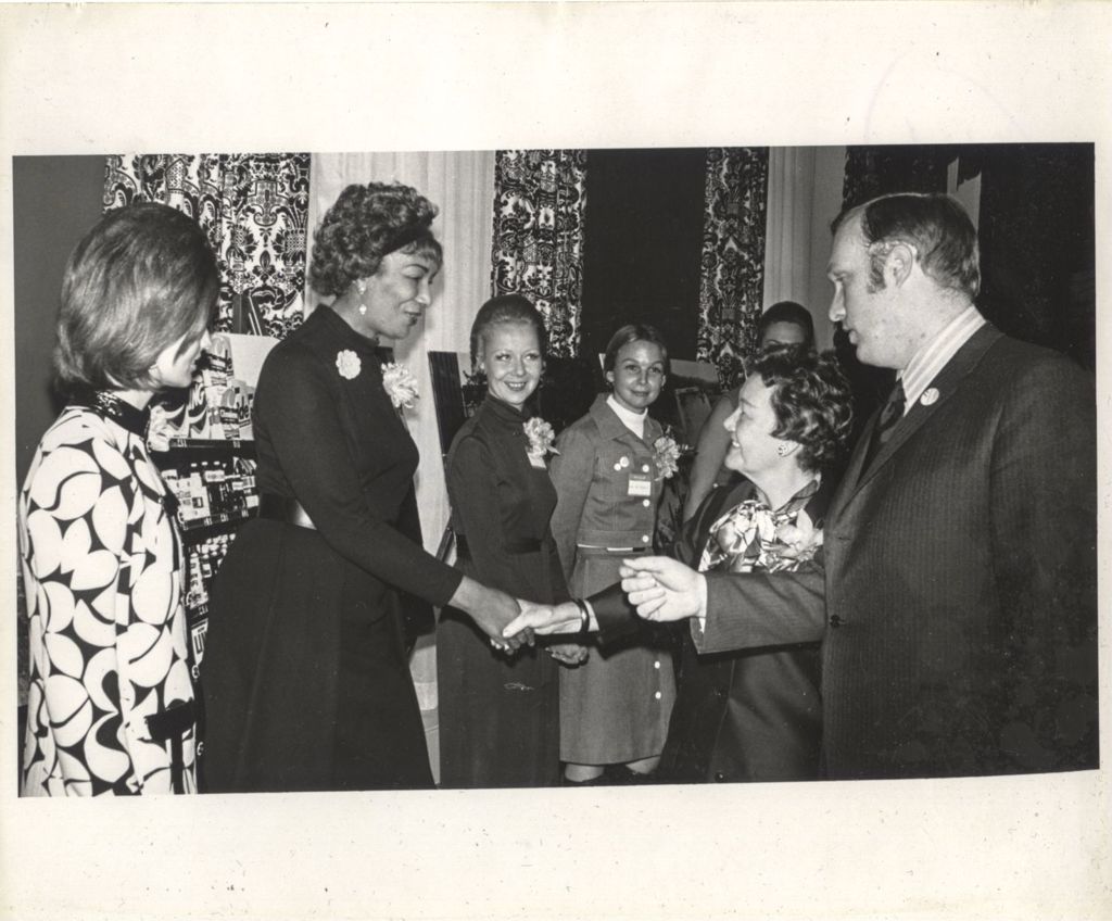 Miniature of Eleanor Daley shaking hands with a woman at a "We Care" event