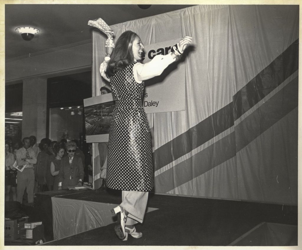 Woman modeling a polka dotted tunic at a "We Care" event