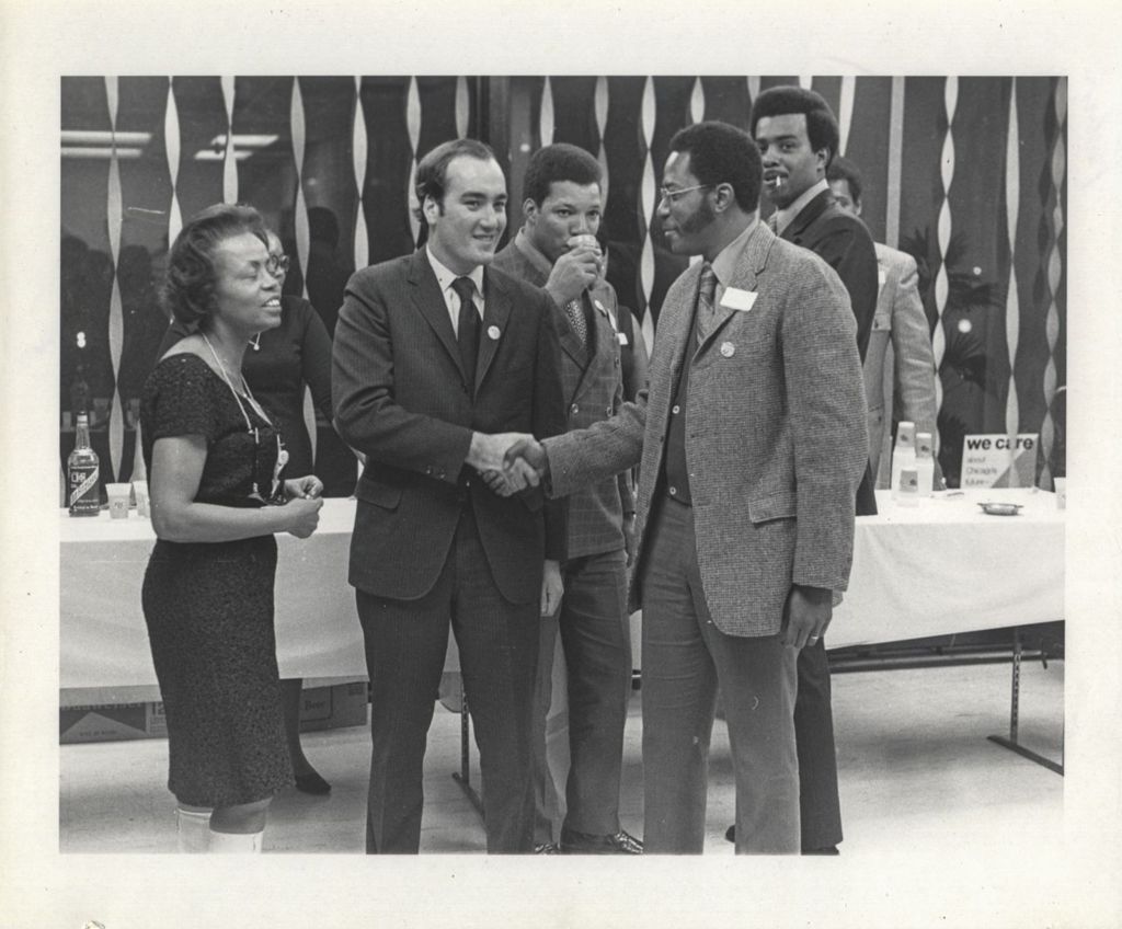 William Daley shaking hands with a man at a "We Care" event