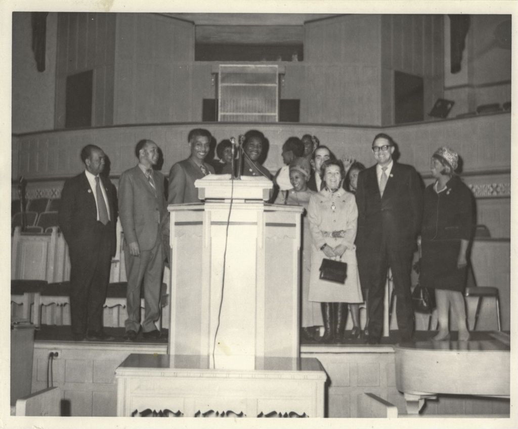 Miniature of Eleanor Daley on a stage with others at a "We Care" event