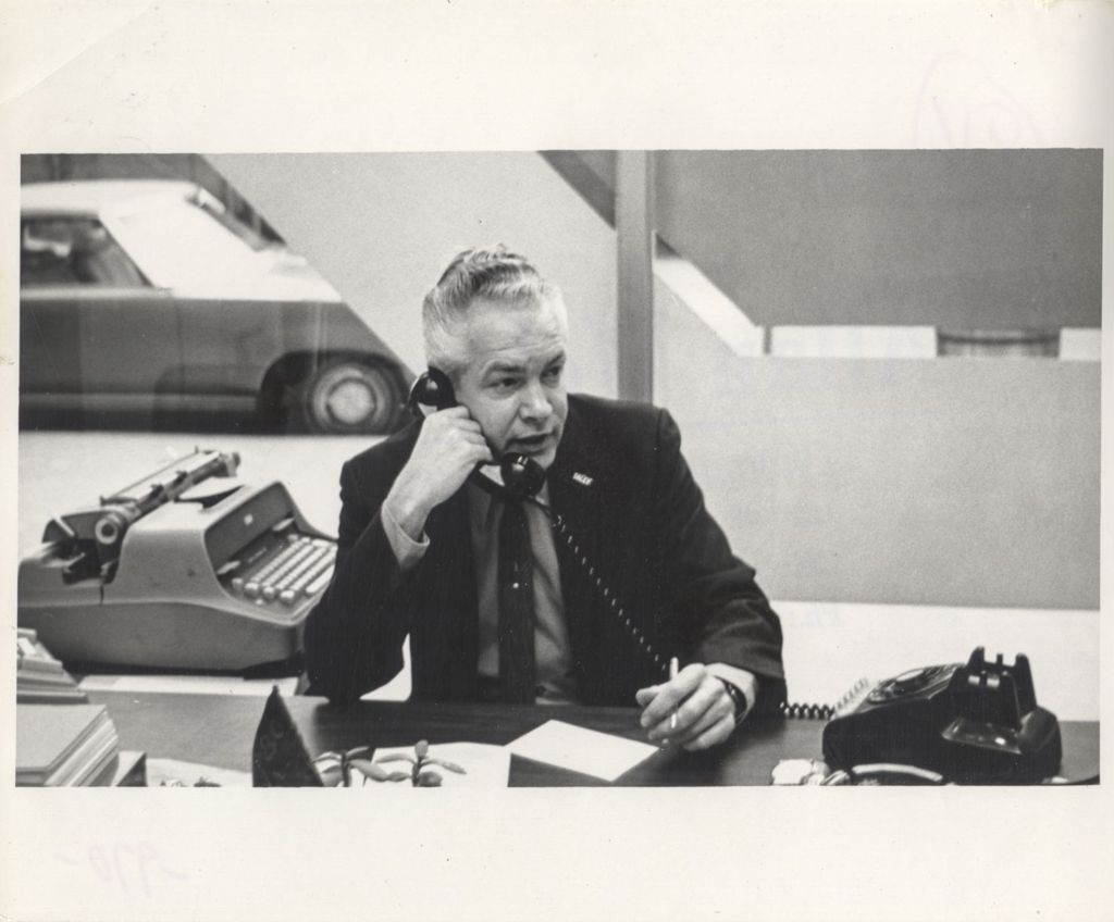 Man on the phone at a desk during the "We Care" campaign