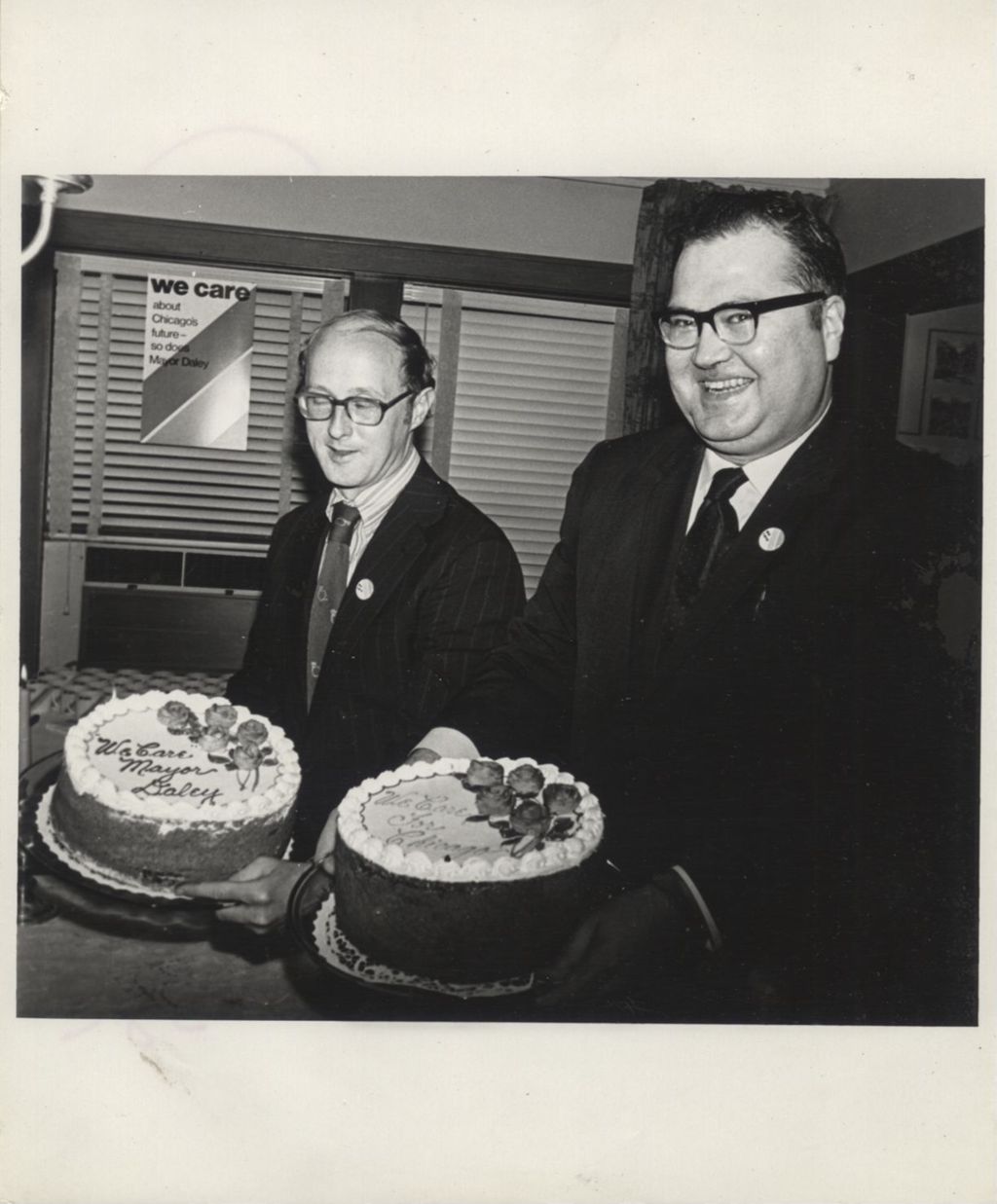 Two men holding cakes that read "We Care Mayor Daley"