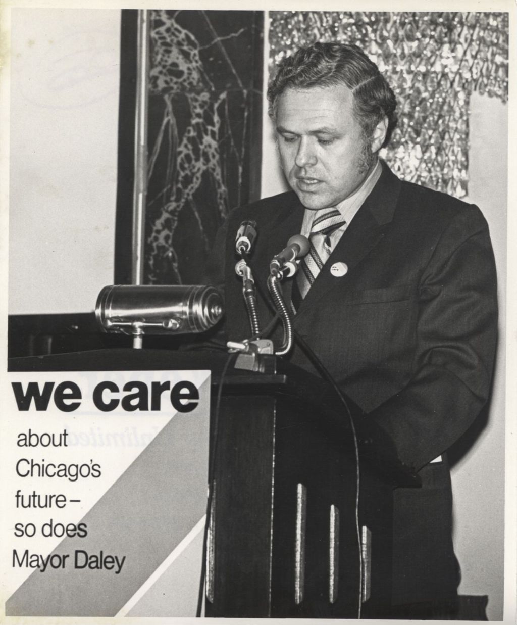 Miniature of Man speaking at a "We Care" event