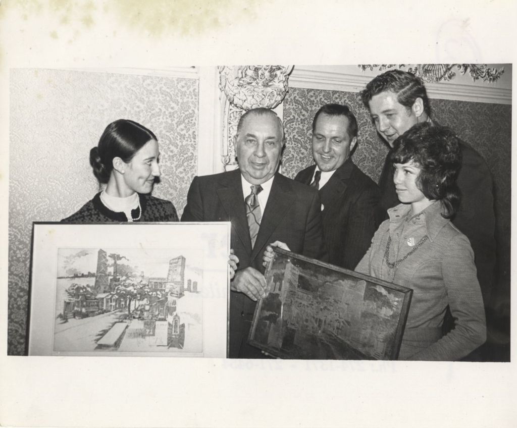 Richard J. Daley holding two framed pictures