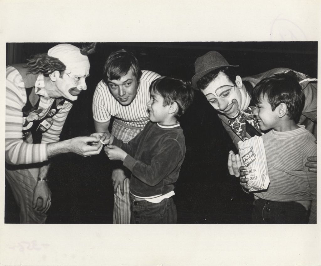 Miniature of Clowns with two young boys at a "We Care" campaign event