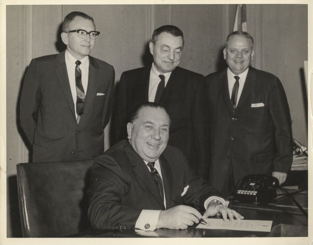 Richard J. Daley signing a document at his desk