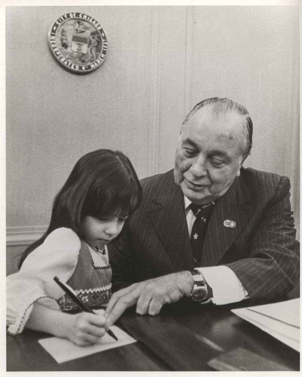 Miniature of Richard J. Daley helping a young girl writing