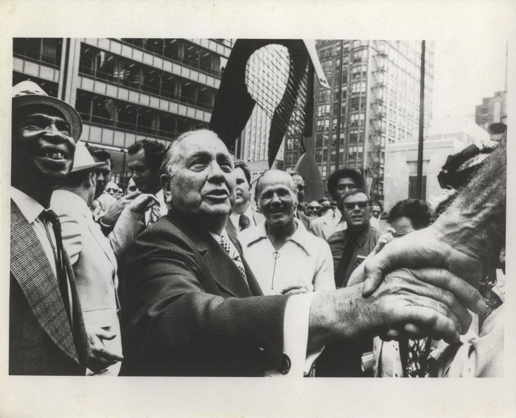 Richard J. Daley shakes hands near the Picasso sculpture