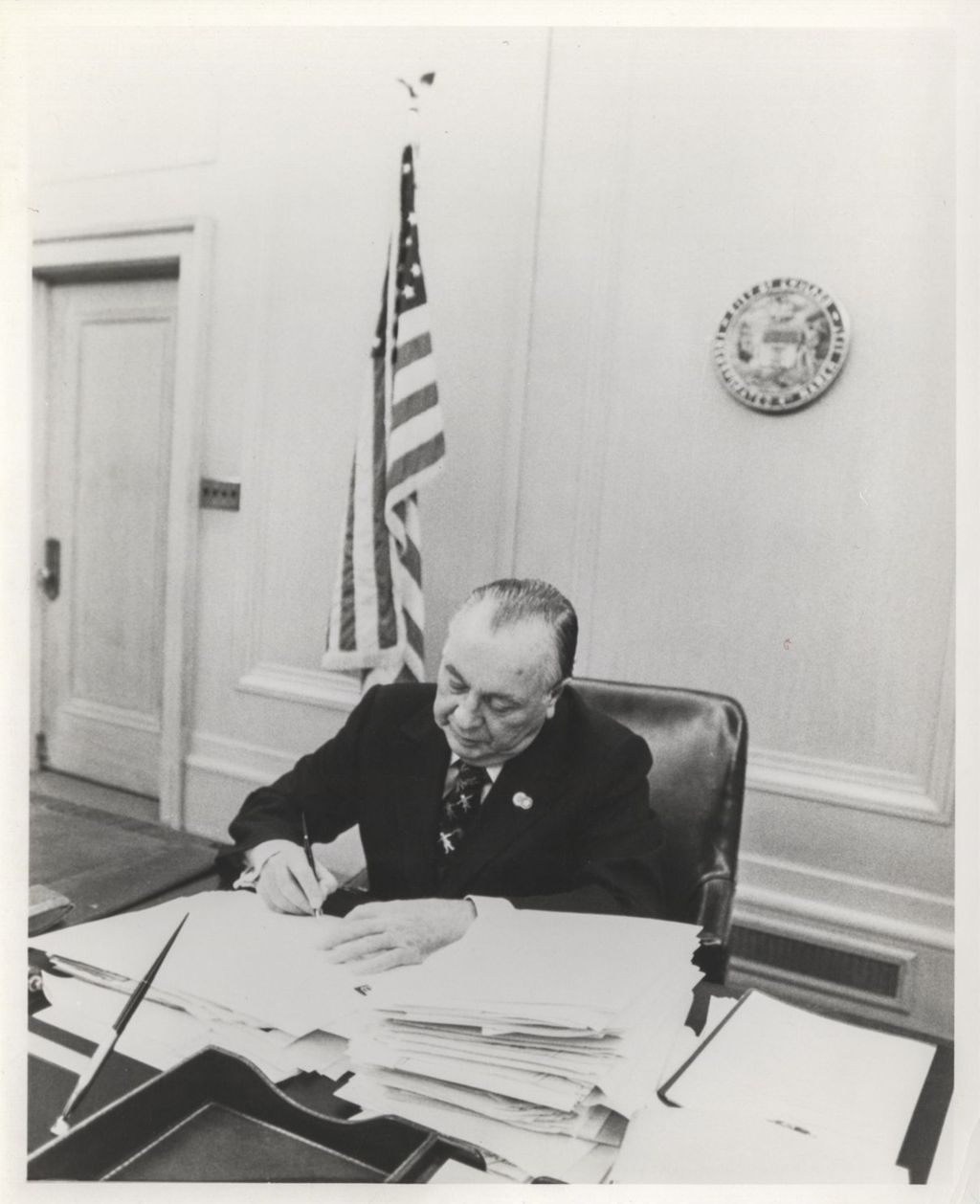 Richard J. Daley signing documents at his desk in City Hall