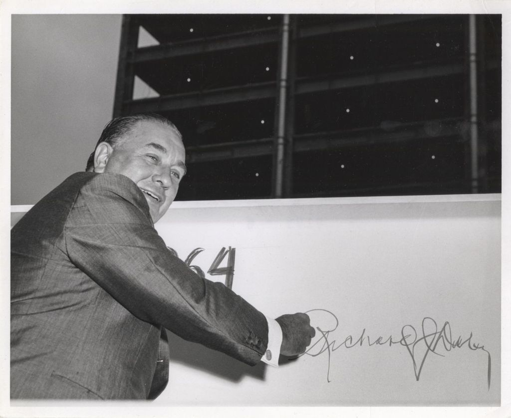 Richard J. Daley at construction site, signing his name