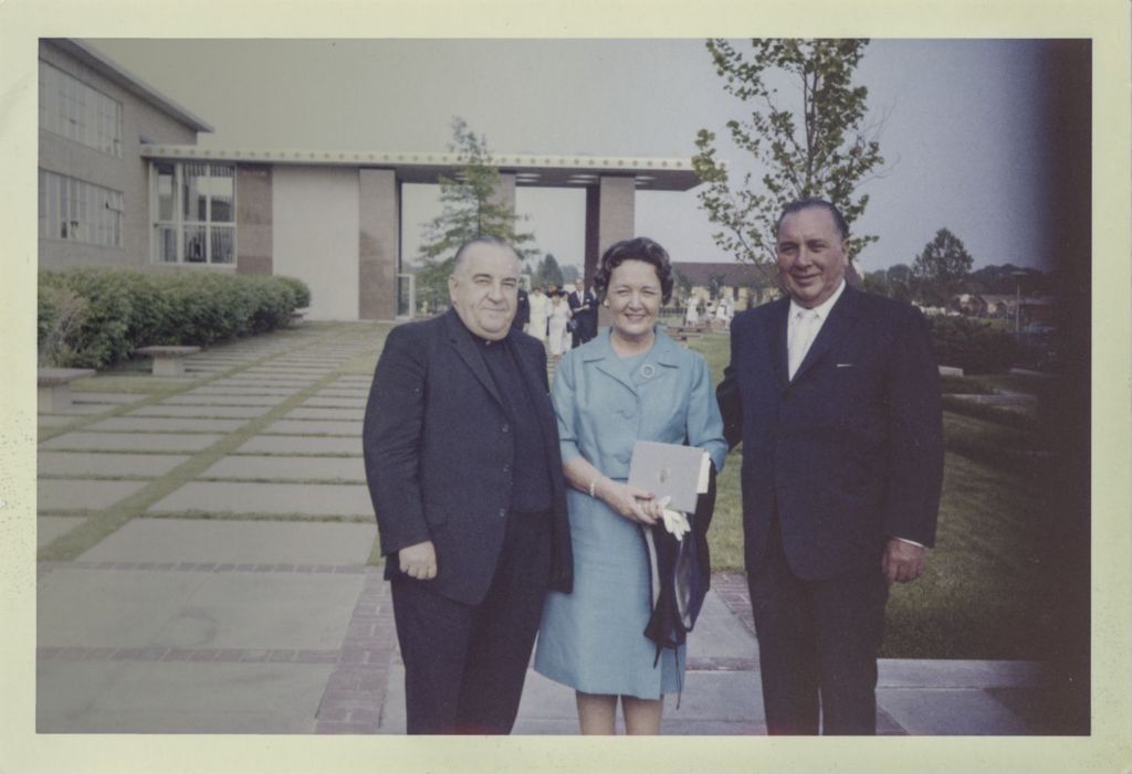 Eleanor and Richard J. Daley and a priest outside a building