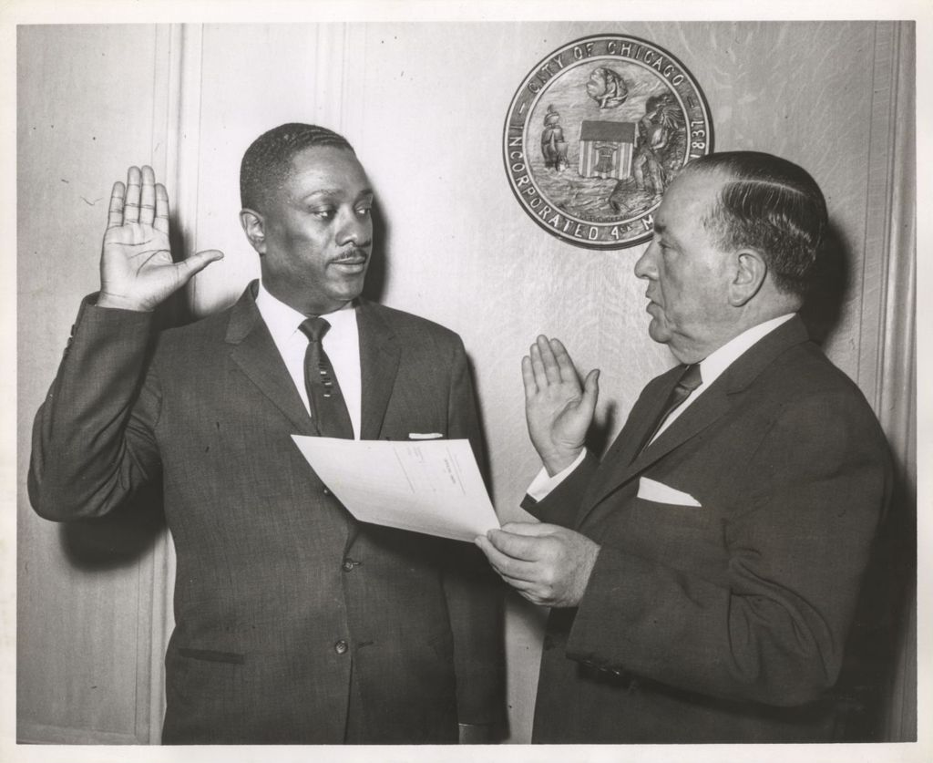 Richard J. Daley swearing in an African American man