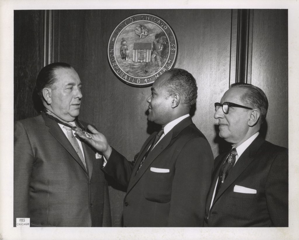 Miniature of Richard J. Daley receives a medal from an African-American man