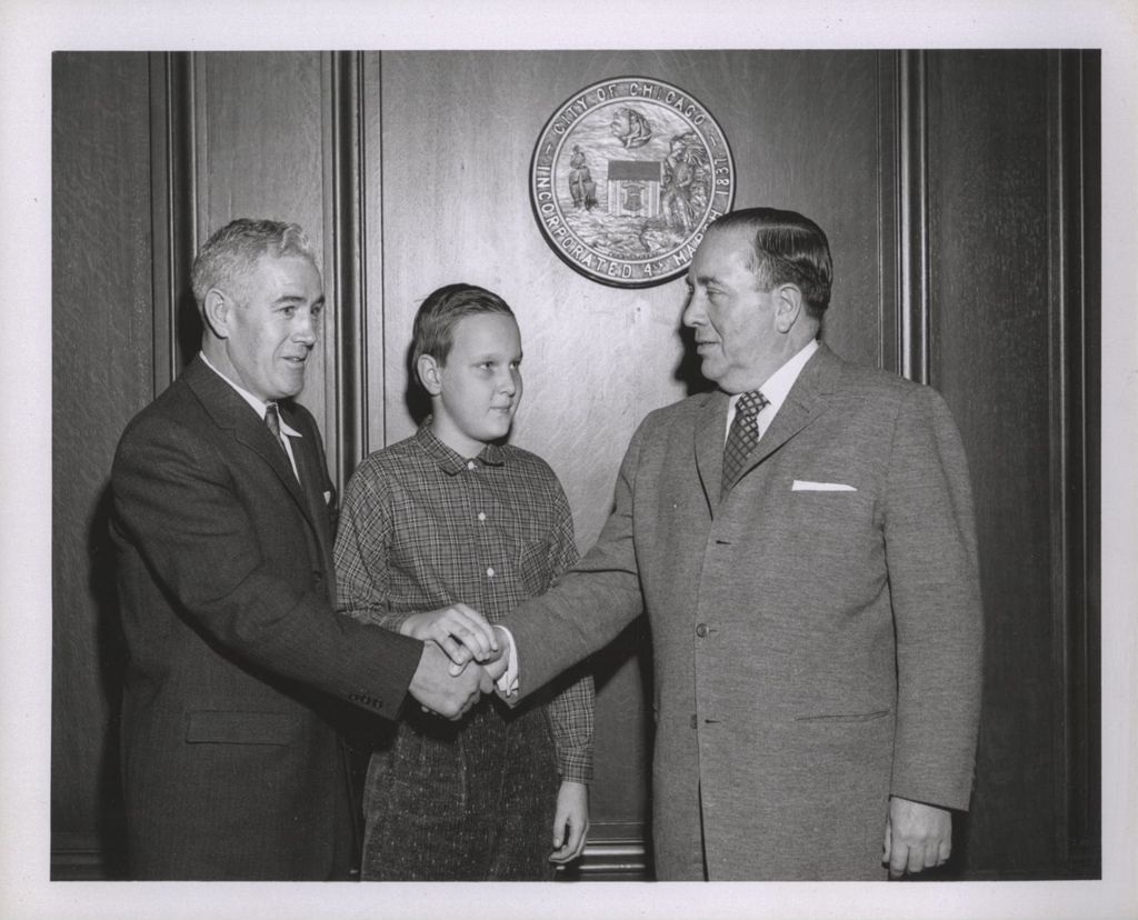 Miniature of Richard J. Daley in a group handshake with a man and boy