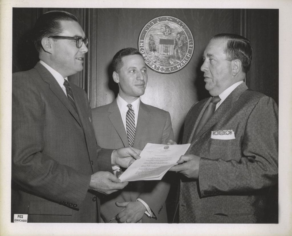 Miniature of Richard J. Daley with two men and a mayoral proclamation