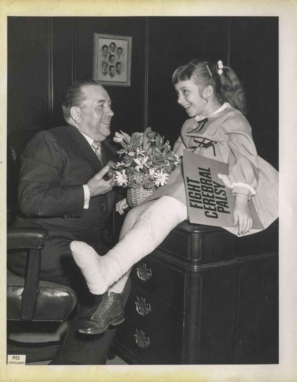 Richard J. Daley with a young girl holding a "Fight Cerebral Palsy" sign