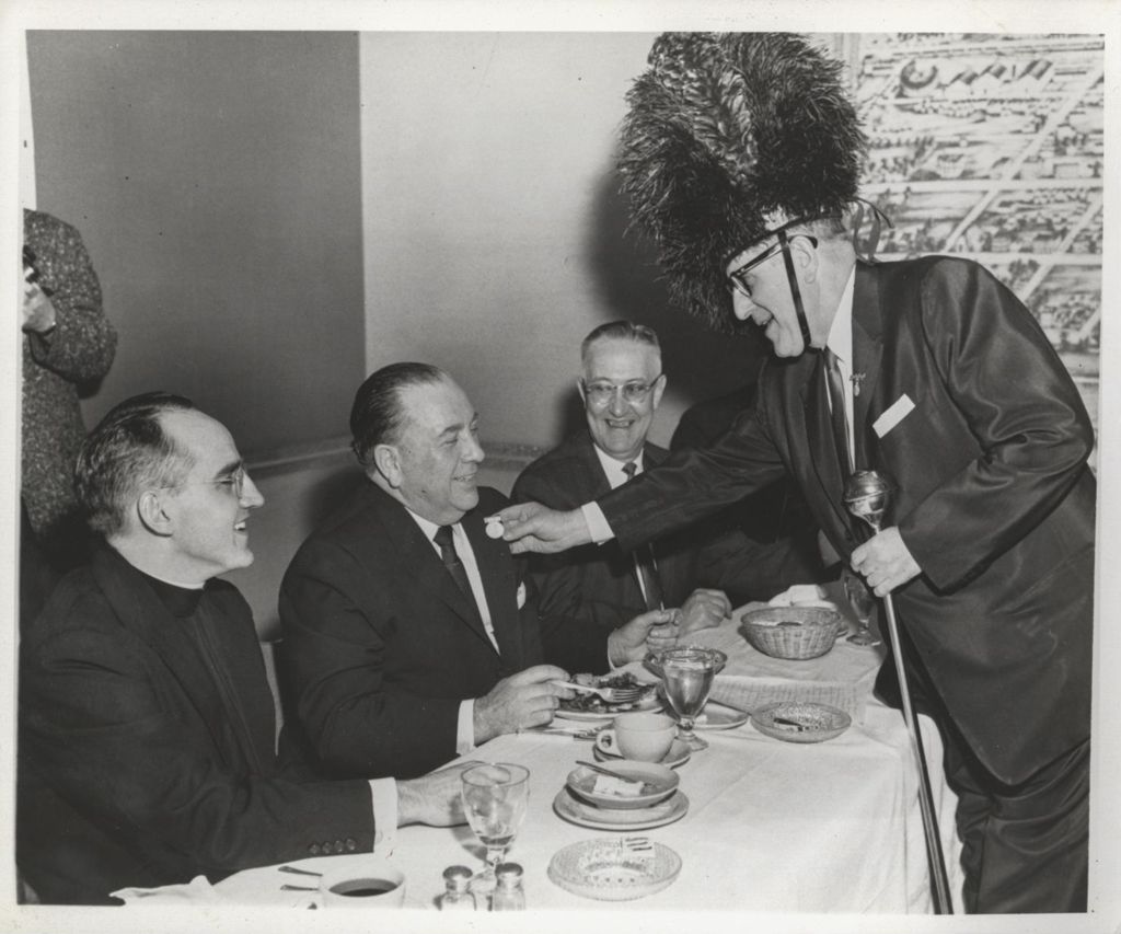 Miniature of Stephen Bailey inspecting Richard J. Daley's lapel at a banquet