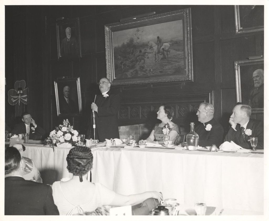 Miniature of Father Murray speaking at an Irish dinner with Eleanor Daley and others