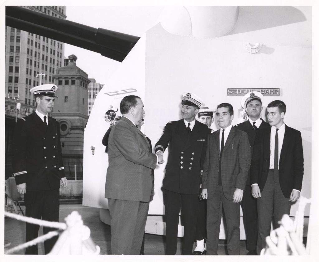 Richard J. Daley on a ship, shaking hands with a naval officer