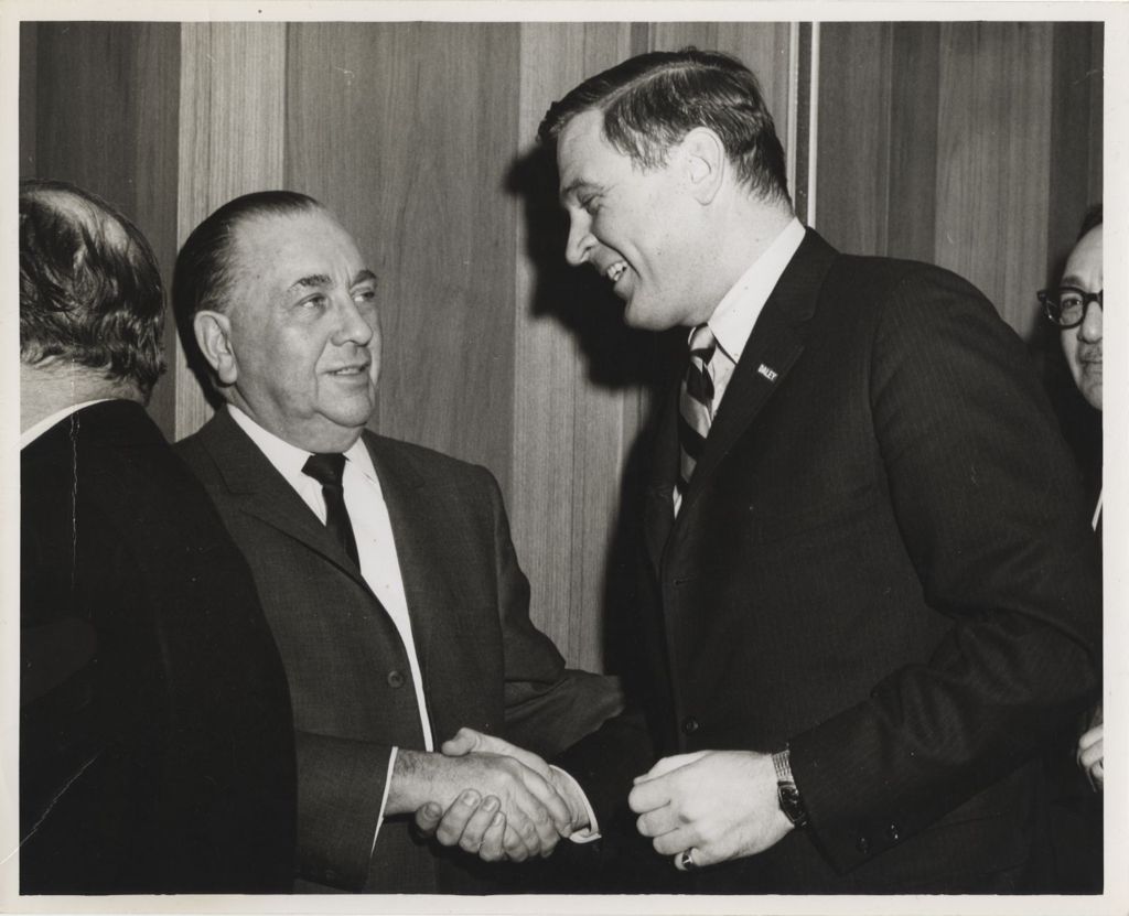Richard J. Daley and Dan Rostenkowski shaking hands