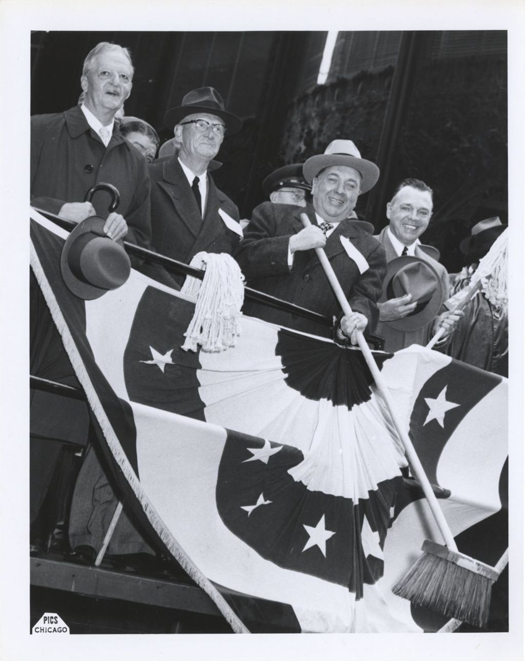 Richard J. Daley with broom on parade viewing stand