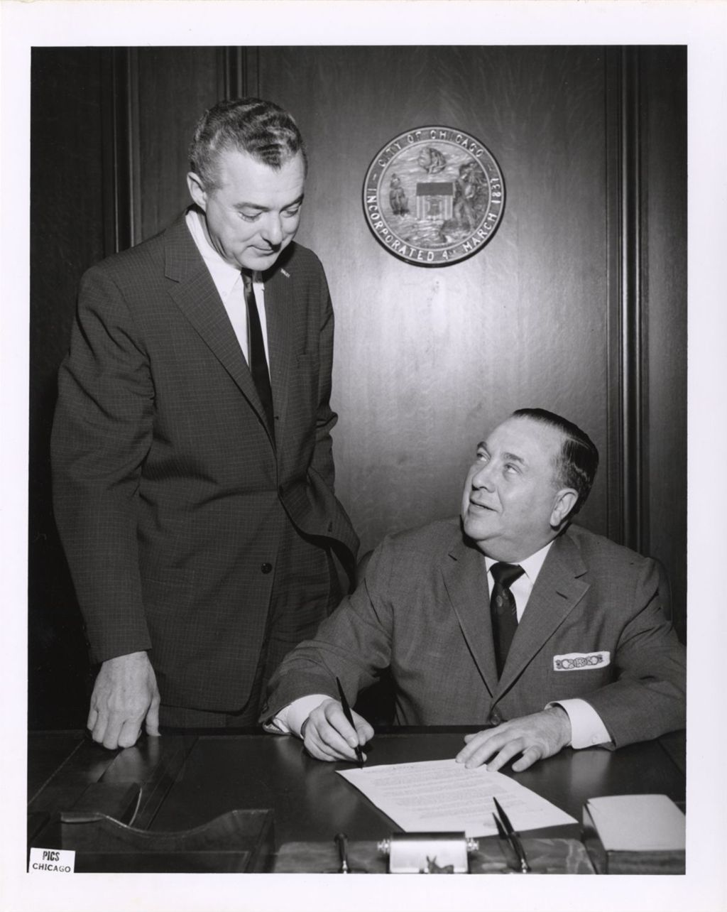 Miniature of Richard J. Daley signing a document at his desk